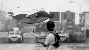 AN UNHAPPY VENEZUELAN A man waves a flag on the road
